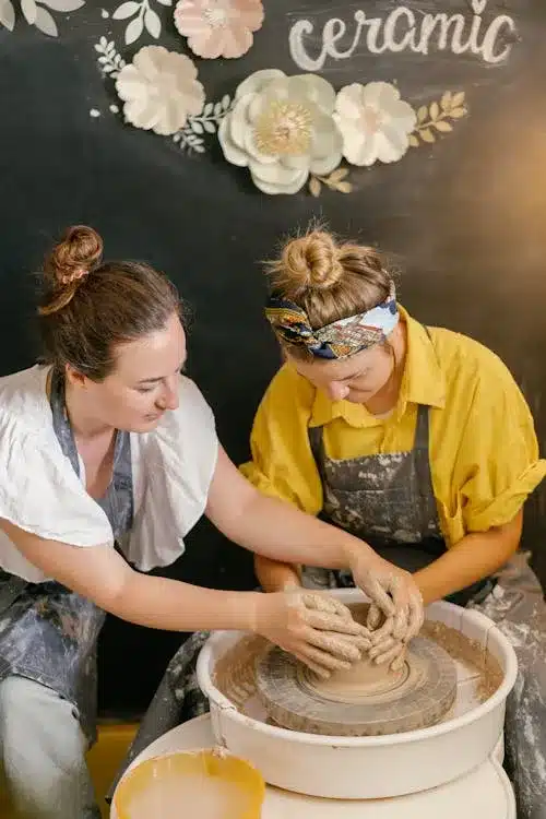 Friends enjoying pottery class together as social self-care activity