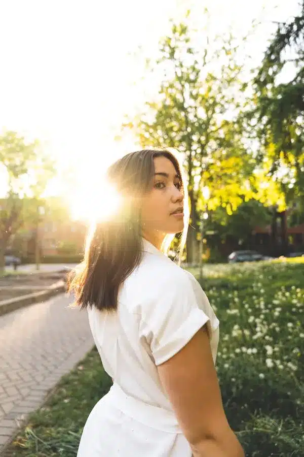 Woman enjoying morning sunlight with coffee during golden hour self-care ritual