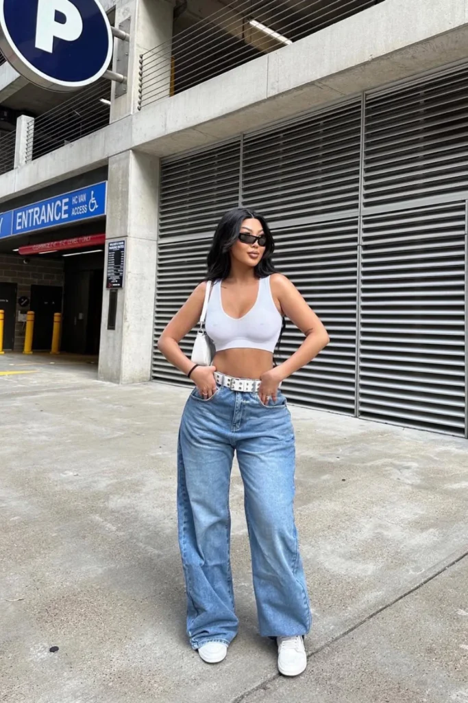 Houston street style featuring a white crop top, relaxed light wash jeans, and classic white sneakers. A perfect minimalist spring outfit with a cool-girl aesthetic.