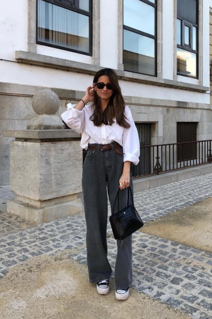 Classic European-inspired look featuring a crisp white button-down, gray wide-leg jeans, and sneakers. A versatile outfit for city exploring and weekend brunch.